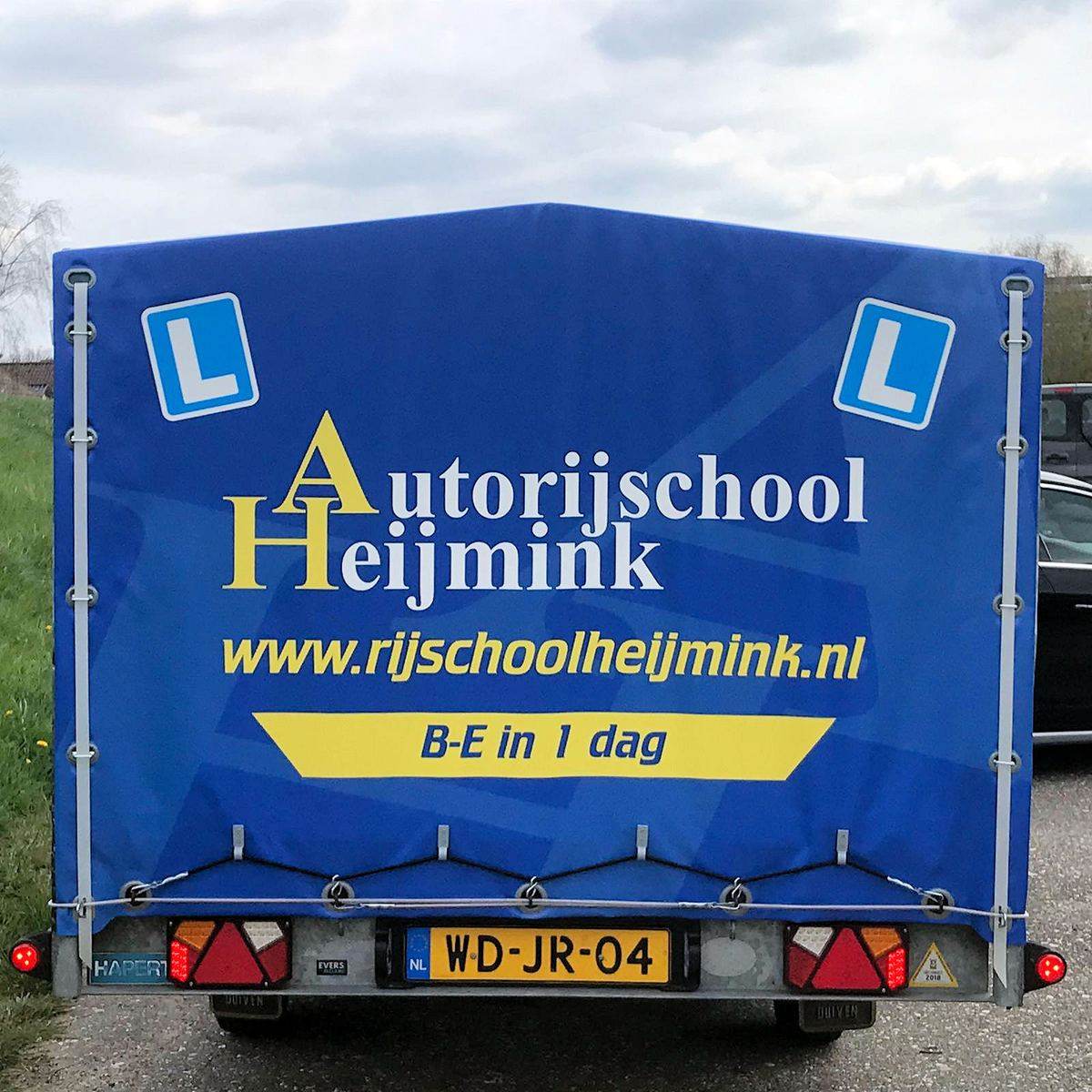 Het bedrukte doek van de B-E aanhanger van Autorijschool Heijmink